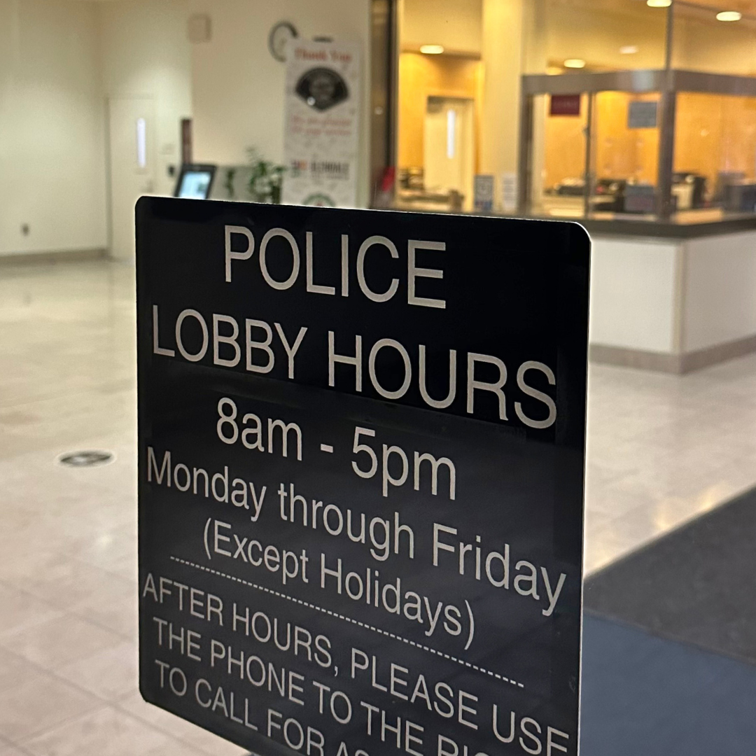 Sign of police station lobby hours Monday - Friday 8 am - 5 pm except holidays